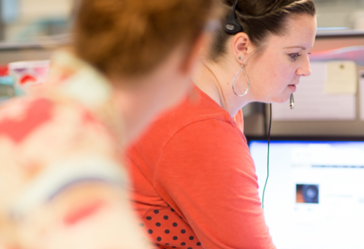 2 people with headsets in a call center